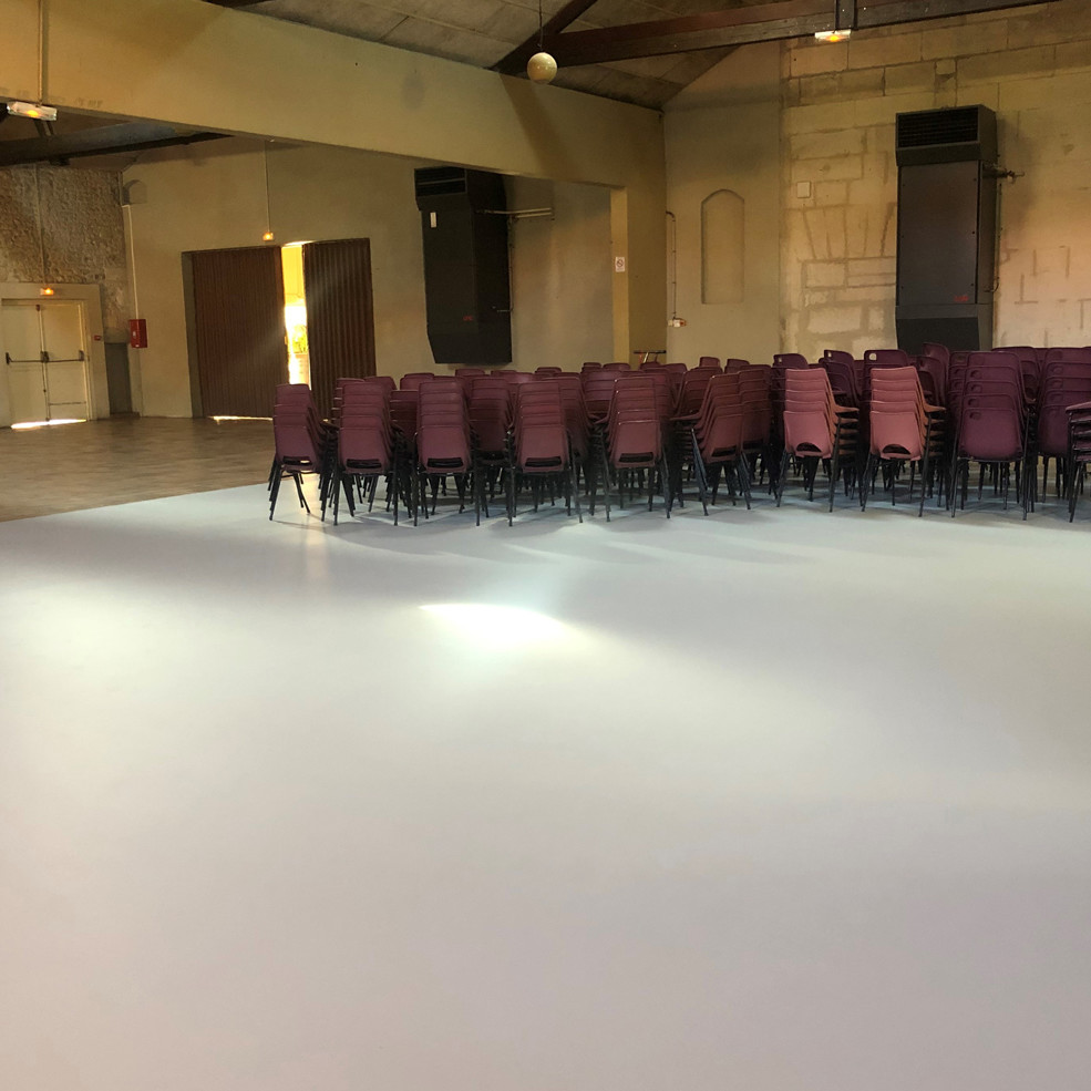 Sol uni en résine appliqué dans une salle de réception pour un rendu esthétique et durable